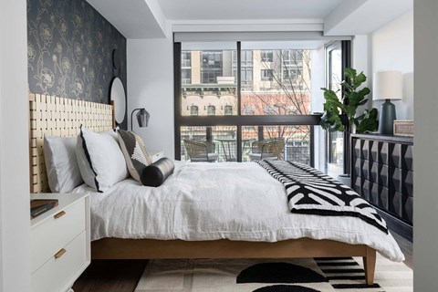 A bedroom with a large bed and a view of the city.