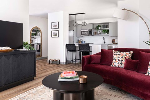 A living room with a red couch and a black coffee table.