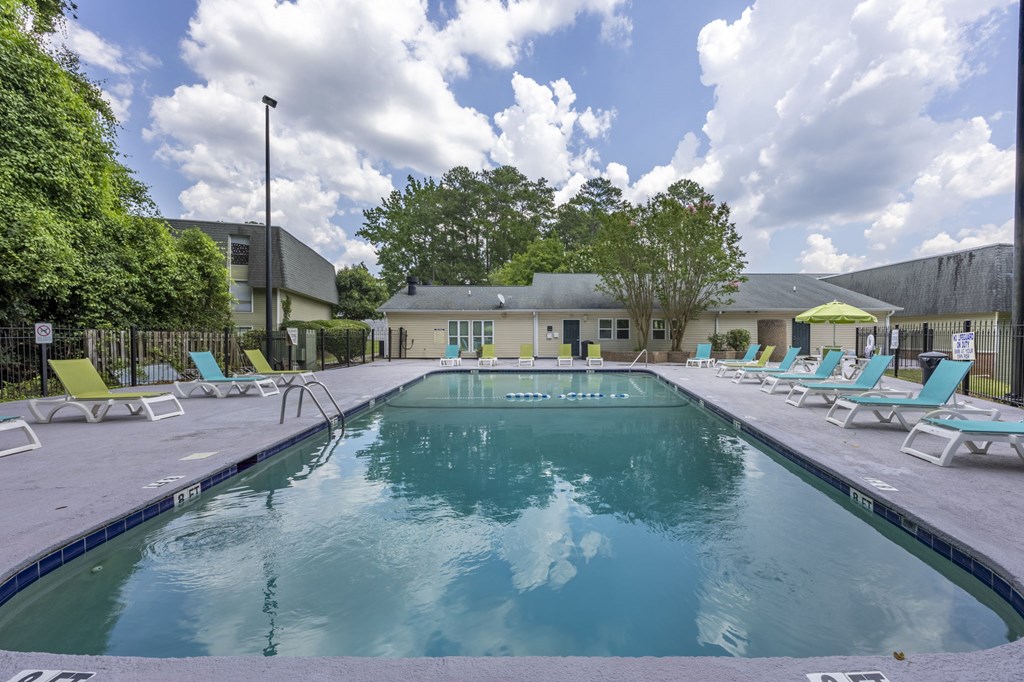 A large outdoor swimming pool surrounded by sun loungers at Peachtree Place Apartments, South Carolina, 29210