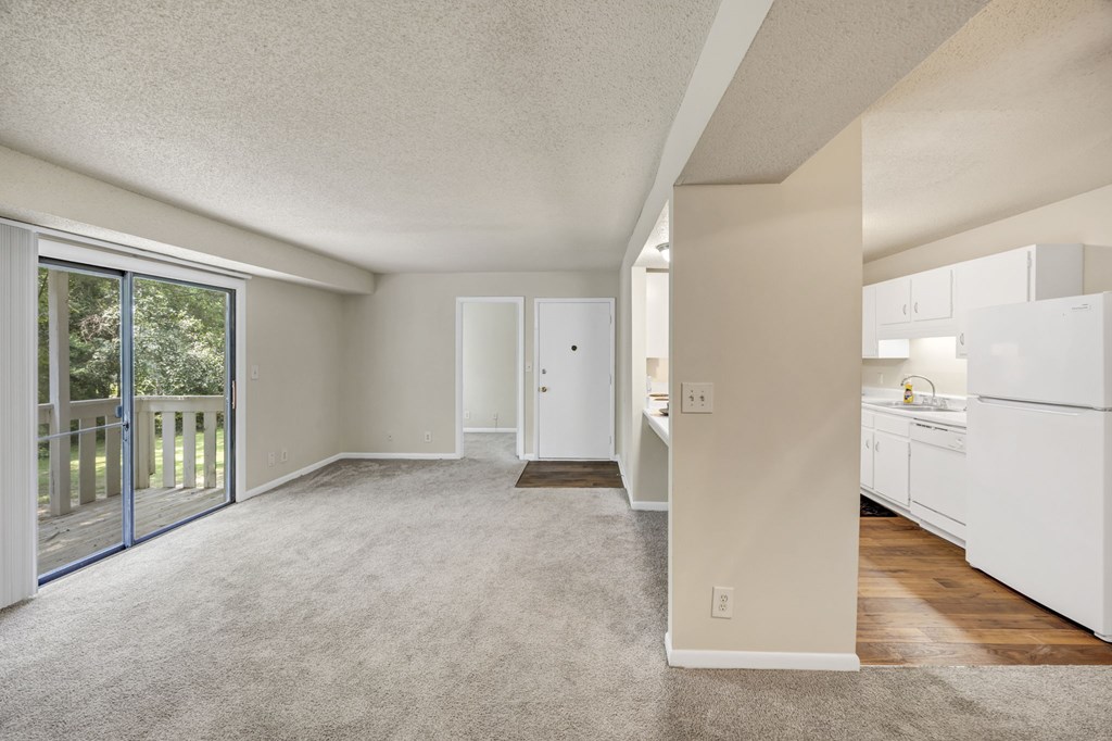 A spacious room with a sliding glass door leading to a balcony at Peachtree Place Apartments, Columbia