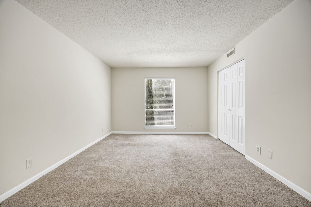 A room with a carpeted floor and a window with blinds at Peachtree Place Apartments, Columbia 29210