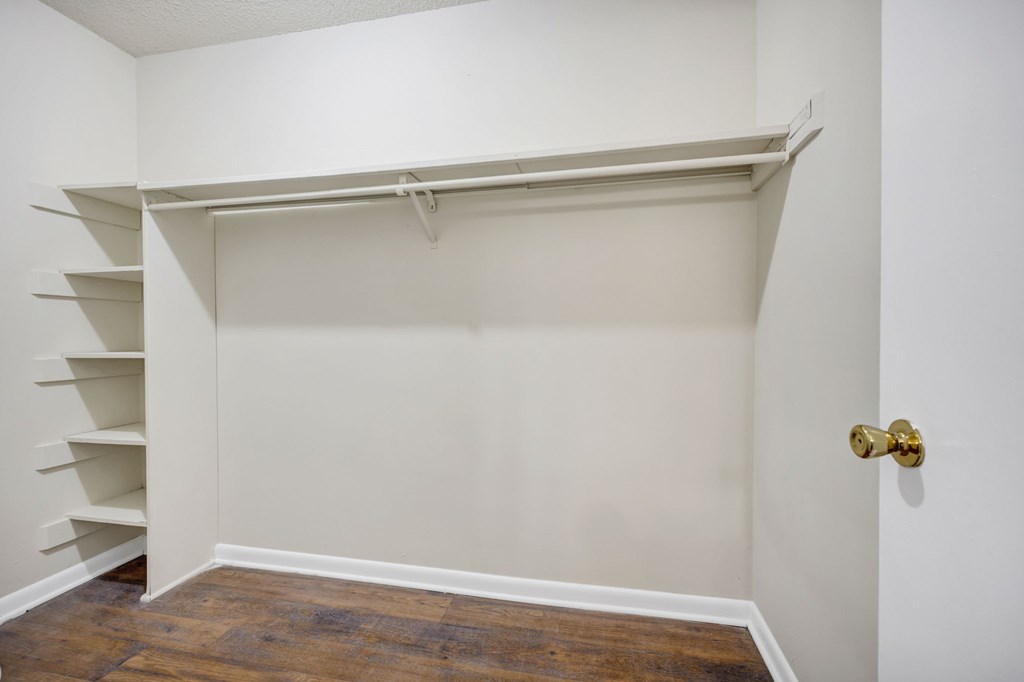 A white closet with a wooden floor and a gold door handle at Peachtree Place Apartments, Columbia