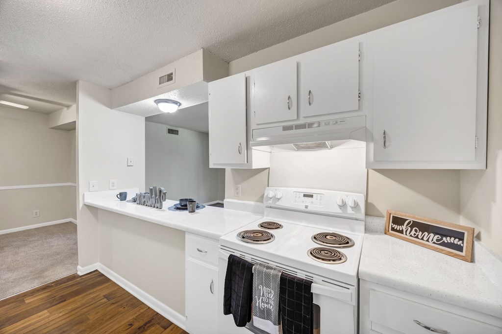 A kitchen with white appliances and cabinets at Peachtree Place Apartments, South Carolina