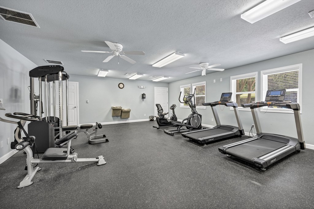 A spacious gym with treadmills, elliptical machines, and a weight bench. at Peachtree Place Apartments, Columbia 29210