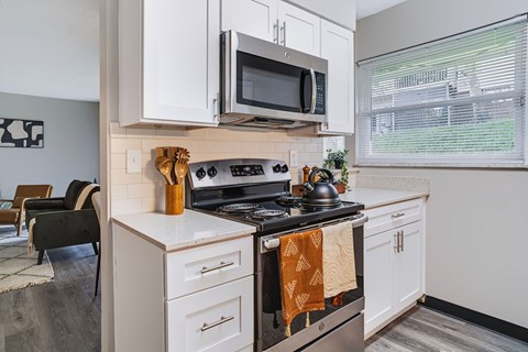 A kitchen with a stove top oven and a microwave above it.