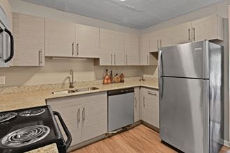 a kitchen with white cabinets and a stainless steel refrigerator
