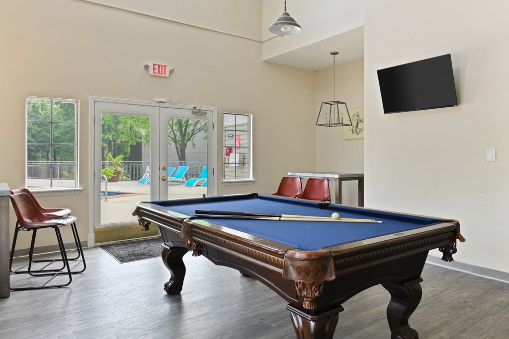 a games room with a pool table and a tv