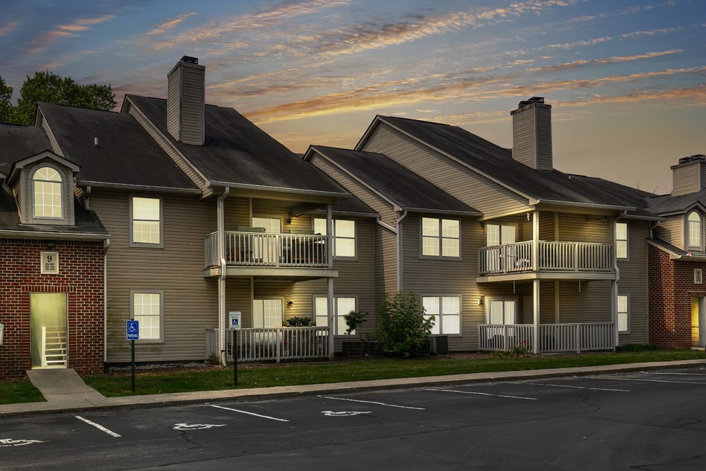 a row of apartment buildings on a street at sunset
