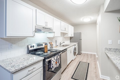 A kitchen with white cabinets and a black stove top.
