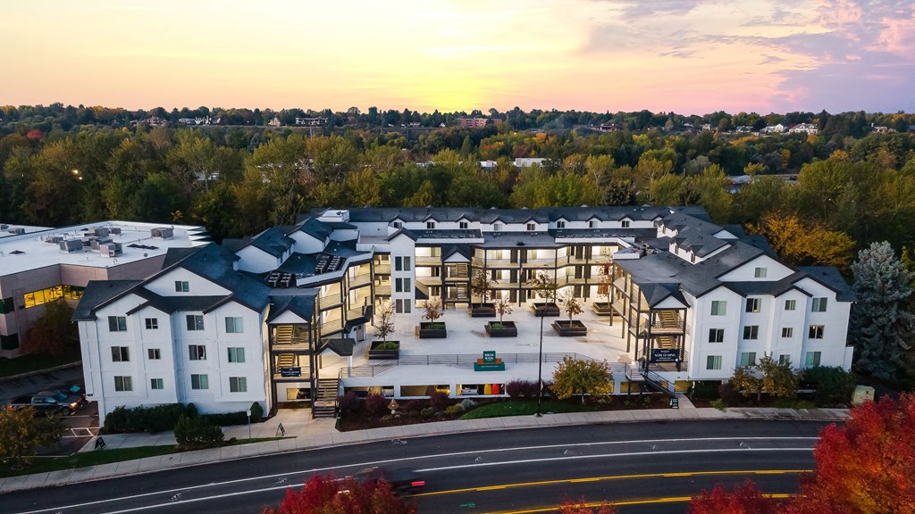 a rendering of an apartment building with a sunset in the background