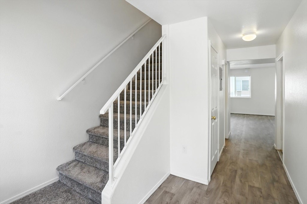 A hallway with a staircase and a door. at Oakstone Apartments, Clearfield