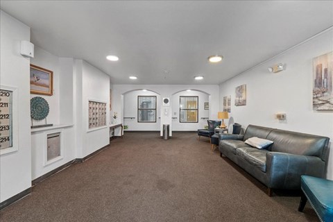 A living room with a couch, a coffee table, and pictures on the wall.