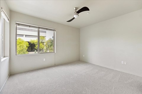 A room with a window and a ceiling fan.