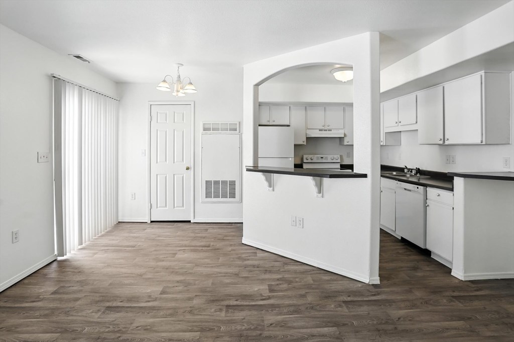 A kitchen with white cabinets and a wooden floor. at Oakstone Apartments, Clearfield, UT