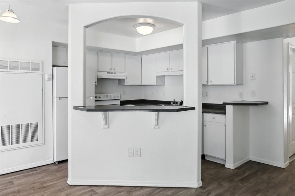 A kitchen with white cabinets and a black countertop. at Oakstone Apartments, Clearfield, UT, 84015