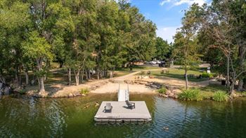 A park with a bench and a table in the middle of a pond.