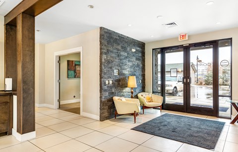 the lobby of a hotel with two chairs and a rug at Corso Apartments, Missoula, MT