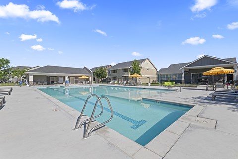 A large outdoor swimming pool with a diving board.
