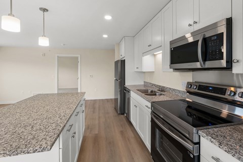 A kitchen with granite countertops and stainless steel appliances at The Beaumont Apartments, Montana, 59715