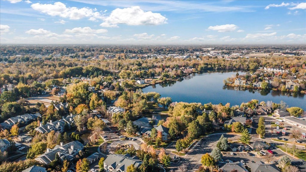 an aerial view of a lake surrounded by houses and trees
