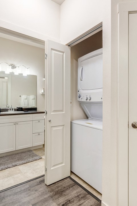a laundry room with a washer and dryer and a door to the bathroom at Corso Apartments, Missoula, MT