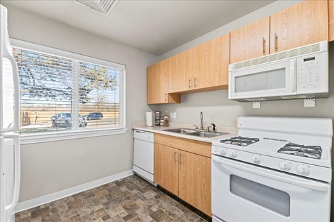 A kitchen with a white fridge, white microwave, white stove and white oven.