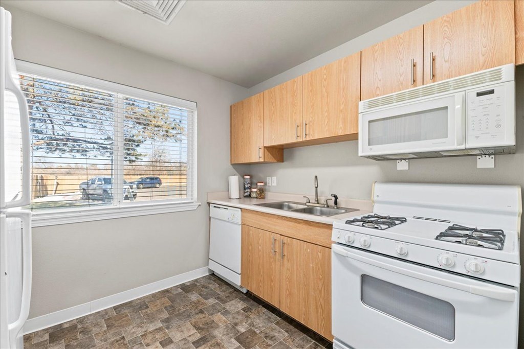 A kitchen with a white fridge, white microwave, white stove and white oven.