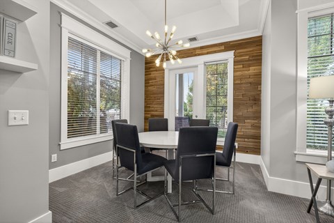 A dining room with a table and chairs.