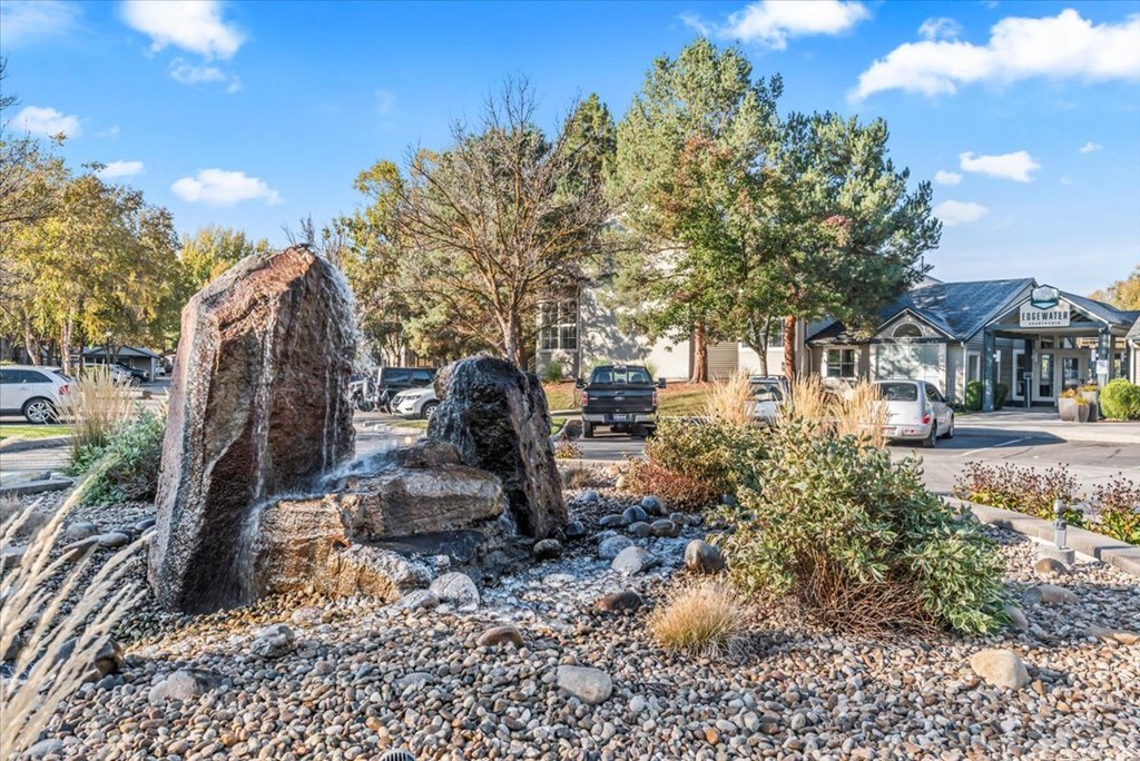 three large rocks in a rock garden in front of a house