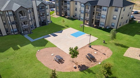 an aerial view of an outdoor basketball court in front of an apartment building