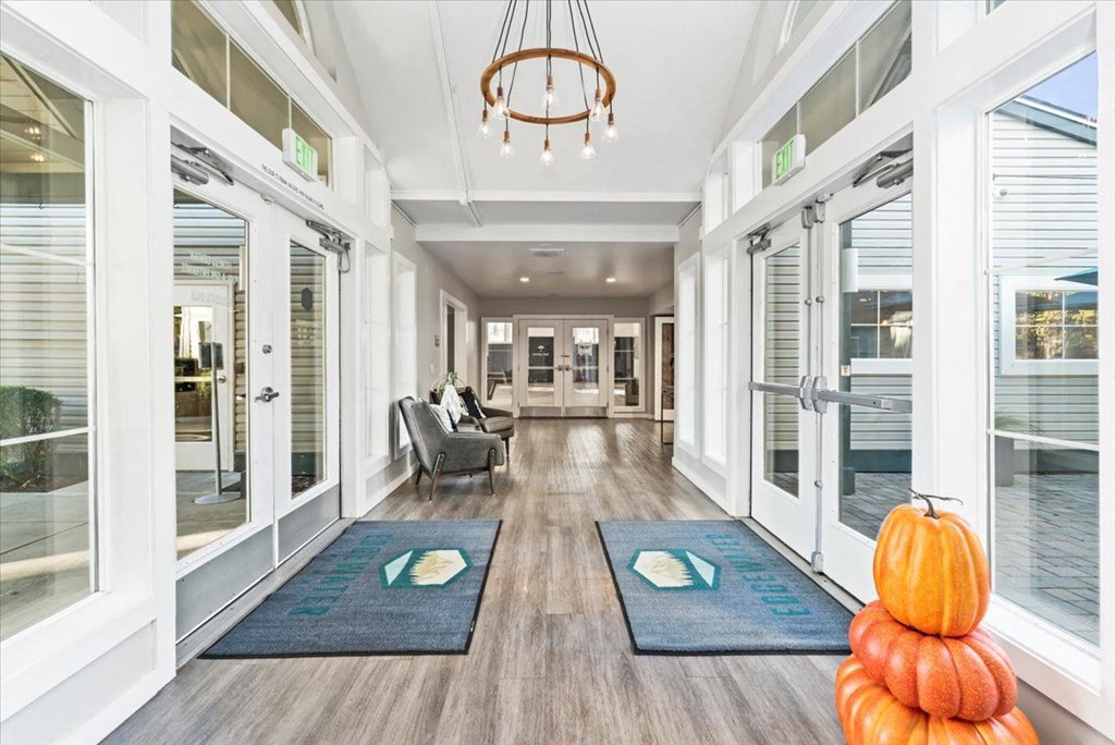 a long hallway with doors and a halloween pumpkin on the floor