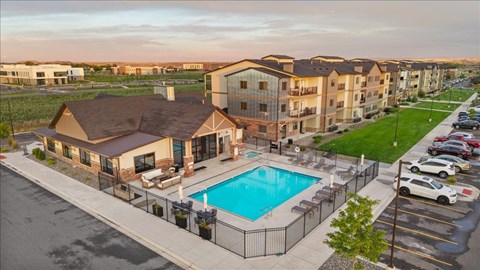 A large apartment complex with a pool in the foreground.