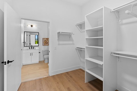 A white room with a kitchenette and shelving.