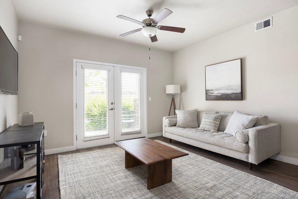a living room with a couch coffee table and a ceiling fan