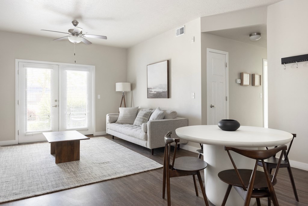 a living room with a couch a table and a ceiling fan