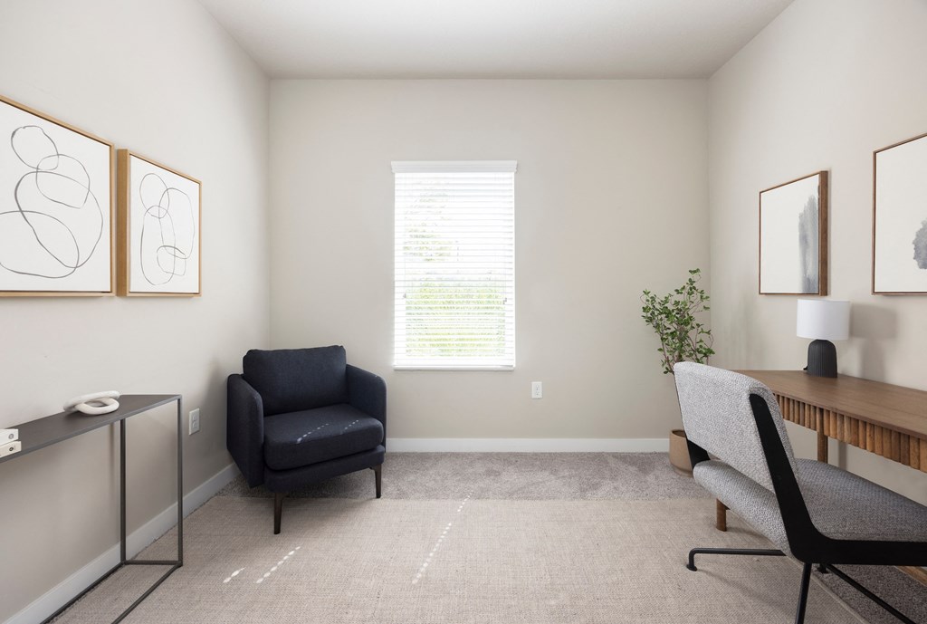 an office with a black chair and a wooden desk