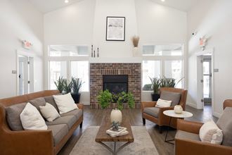 a living room with white walls and a brick fireplace