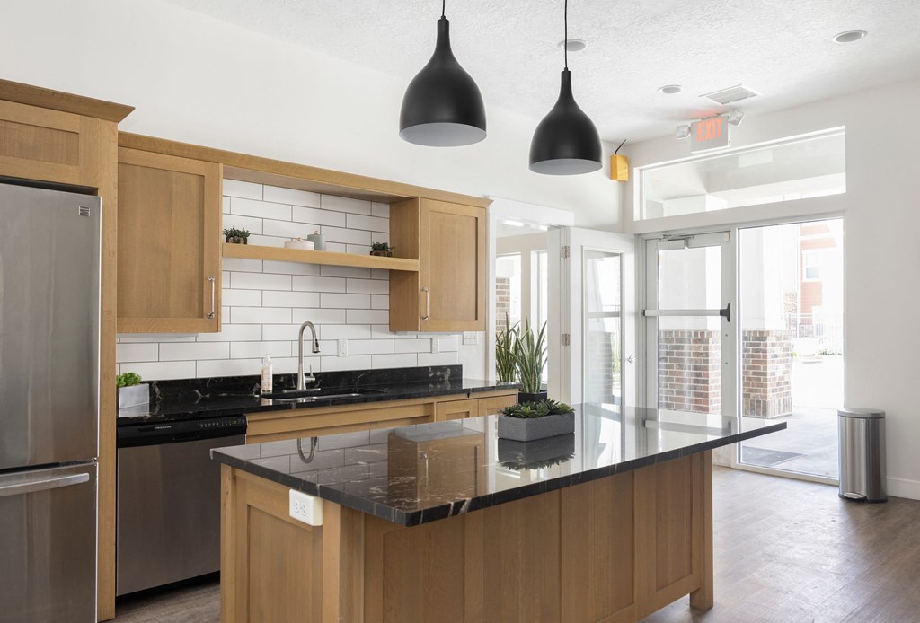 a kitchen with wooden cabinets and a large island with a black countertop