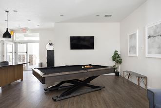 a living room with a pool table and a flat screen tv on the wall - Photo Gallery 2