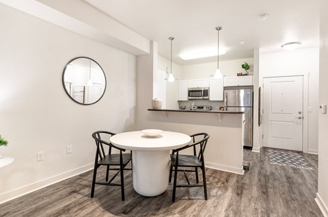 a kitchen and dining room with a white table and chairs at Corso Apartments, Missoula, MT