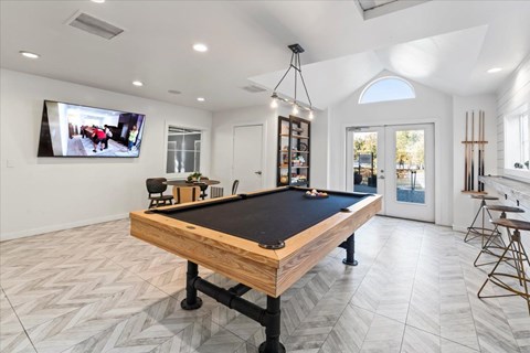 a pool table in a game room with a tv
