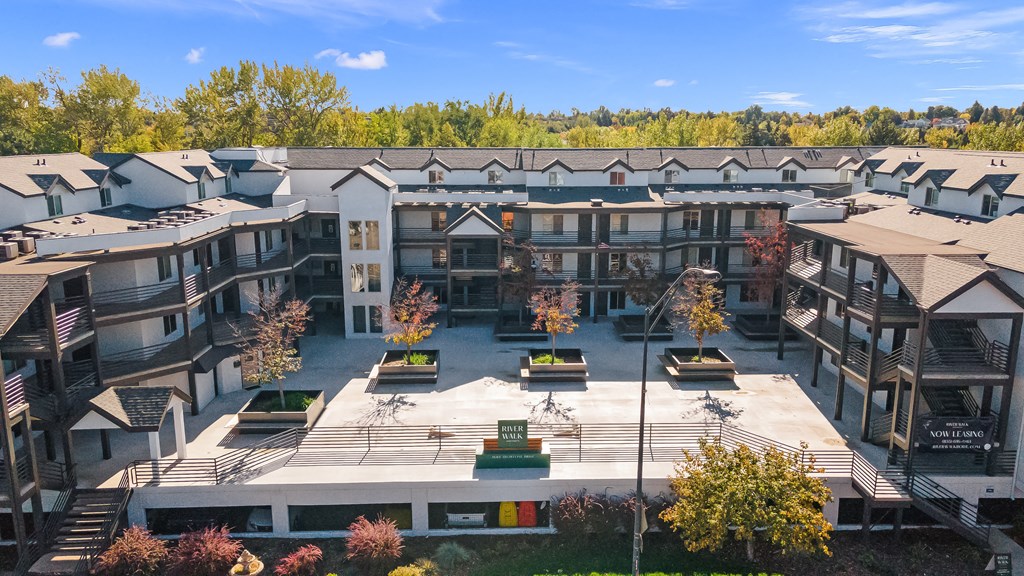 an aerial view of an apartment complex with trees in the background