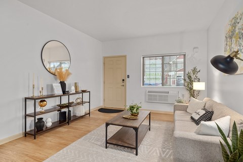A living room with a couch, coffee table, and a mirror.