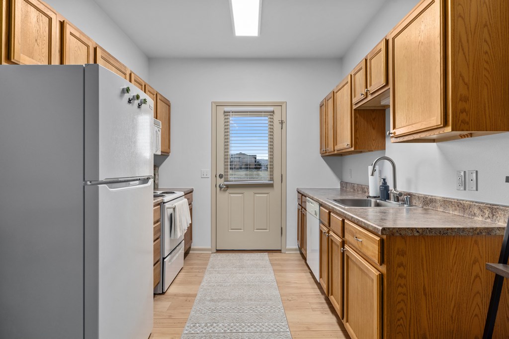 A kitchen with wooden cabinets and a white refrigerator.