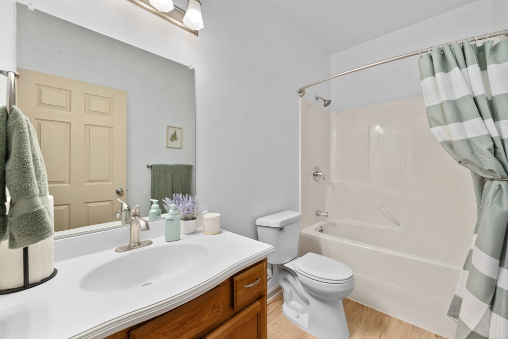 A bathroom with a white sink, toilet, and bathtub.