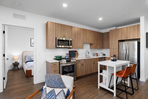 A kitchen with a white table and chairs and a bed in the corner.