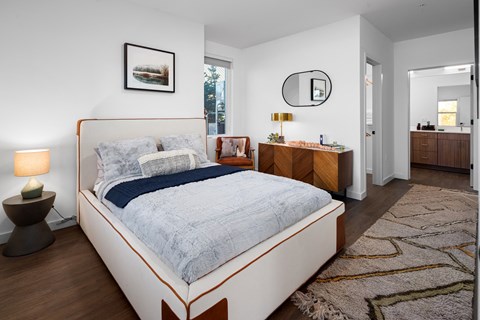 A bedroom with a large bed and a wooden dresser.