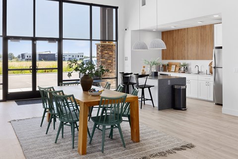 a kitchen and dining room with a wooden table and green chairs