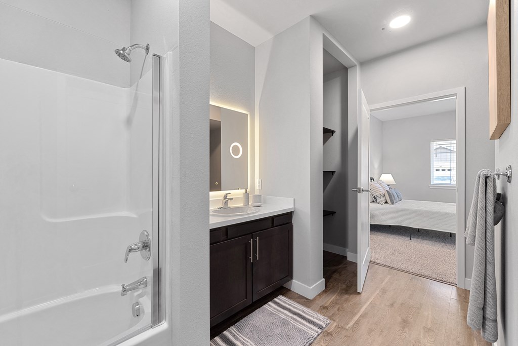 a bathroom with a shower and a sink and a mirror