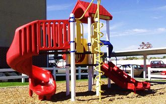 a childrens playground with a red slide